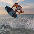 Skimboarder Mid-Air at Sunset